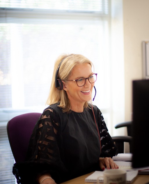 Fiona, Managed Care Local Consultant, smiling whilst talking on the phone